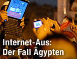 Mann in Menschenmenge hält Laptop in den Händen
