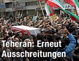Menschen tragen Sarg zum Begr&auml;bnis