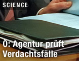 Mann blättert in Aktenmappe