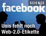 Silhouetten vor Facebook-Schriftzug