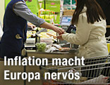 Frau bezahlt in einem Lebensmittelgeschäft