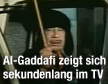 Der libyische Staatsf&uuml;hrer Muammar al-Gaddafi spricht aus einem Auto mit einem wei&szlig;en Regenschirm in der Hand