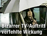 Der libyische Staatsf&uuml;hrer Muammar al-Gaddafi spricht aus einem Auto mit einem wei&szlig;en Regenschirm in der Hand