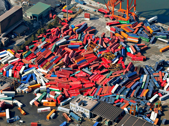© AP/Itsuo Inouye Container liegen im Hafen Sendai auf einem Haufen