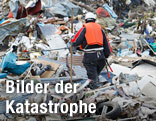 Rettungshilfskraft in den Tr&uuml;mmern auf der Suche nach &Uuml;berlebenden
