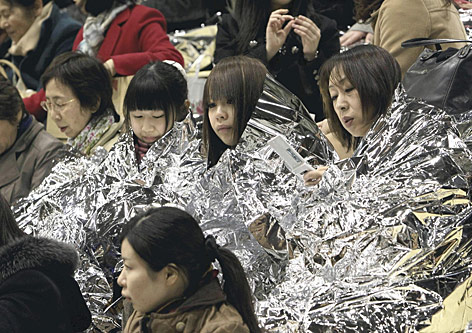 © AP/The Yomiuri Shimbun, Reiri Kurihara Studenten der Aoyama Gakuin Universität in Tokio haben sich in Notfallsdecken gehüllt.