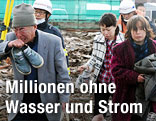 Verzweifelte Menschen in den Tr&uuml;mmern