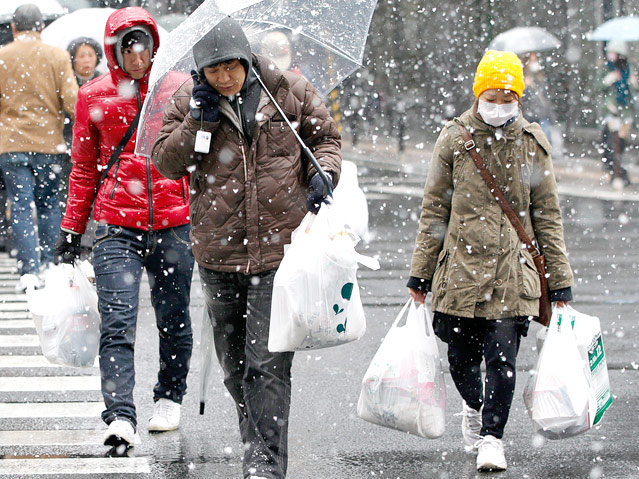 © Reuters/Jo Yong hak Bewohner tragen ergatterte Lebensmittel bei Schneefall nach Hause