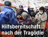 Rettungskr&auml;fte helfen &auml;lteren Personen