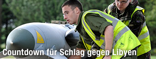 Soldaten beladen einen Kampfjet mit Waffen