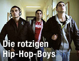 Szene aus "Schwarzkopf" in der drei männliche Jugendliche einen Gang entlang gehen