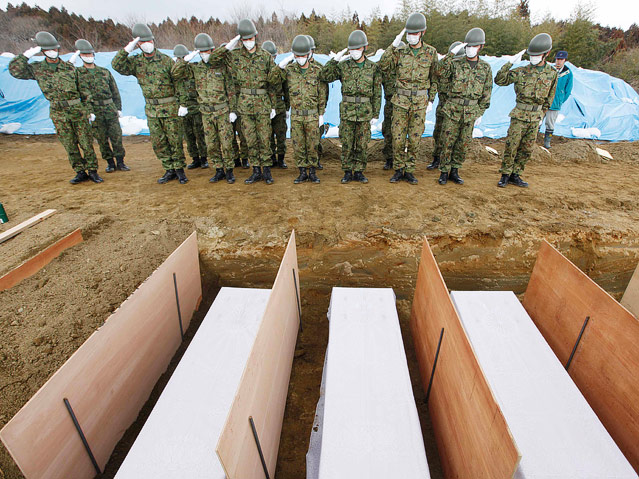 © AP/Mark Baker Japanische Soldaten salutieren vor Gräbern