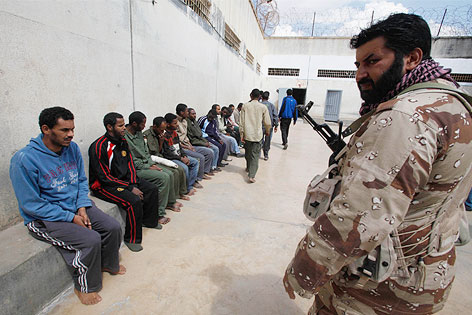 © Reuters/Suhaib Salem Rebelle bewacht Gaddafi-Treue in einem Gefängnis in Benghazi