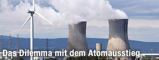 Vor einem franz&ouml;sischen AKW steht ein Windrad