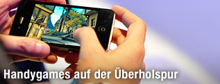 Ein Mann spielt ein Game auf einem IPhone