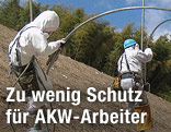 Arbeiter in Schutzanz&uuml;gen arbeiten an einer Hochspannungsleitung.