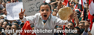 Bub mit Brotlaib bei einer Demonstration am Tahrir-Platz