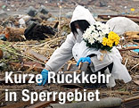 Frau sucht nach persönlichen Gegenständen in der Sperrzone rund um das AKW Fukushima