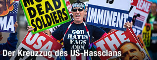 Ein Mitglied der Westboro Baptistenkirche h&auml;lt Schilder mit Aufschriften wie "Pray for more dead Soldiers" in die H&ouml;he.