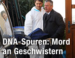 Mitarbeiter eines Bestattungsunternehmens tragen eine abgedeckte Bahre