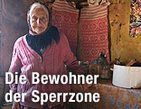 Bewohnerin der Sperrzone steht in ihrem Haus