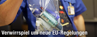 Mann h&auml;lt Plastiks&auml;ckchen mit Fl&uuml;ssigkeiten in die Kamera