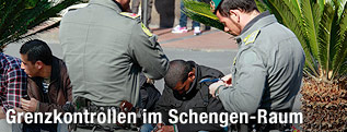 Italienische Grenzbeamte kontrollieren nordafrikanische Fl&uuml;chtlinge