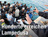 Fl&uuml;chtlinge aus Nordafrika erreichen mit dem Boot die K&uuml;ste von Lampedusa
