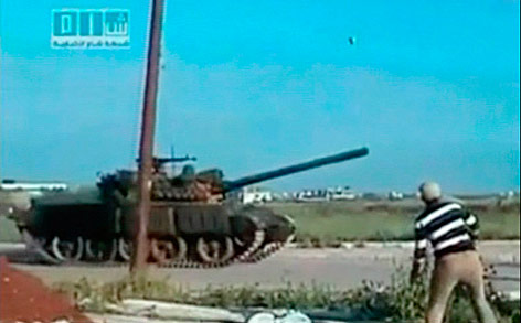 © Reuters Syrischer Mann wirft einen Stein gegen einen Panzer