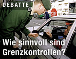 Ein Autofahrer zeigt an der Grenze den Reisepass her