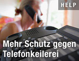 Frau mit Telefonhörer vor Telefon