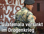 Soldat vor einem mit Blut beschriebenen Haus