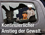 Soldat blickt durch zerschossene Autoscheibe