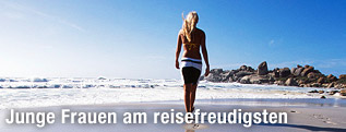 Junge Frau geht am Strand spazieren