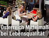 Menschen unterhalten sich bei Sonnenschein im Gastgarten