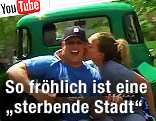 Mann mit Gitarre wird von Frau auf die Wange geküsst