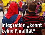 Frau mit Kopftuch geht neben Mann