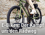 Frau f&auml;hrt mit Elektrofahrrad