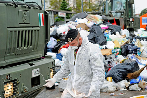 © APA/EPA/ANSA/Ciro Fusco Soldat mit Gesichtsmaske steht im Müllberg