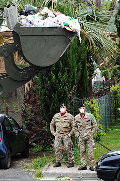 © APA/EPA/ANSA/Ciro Fusco Soldaten mit Gesichtsmaske stehen neben einer mit Müll vollgeüllter Baggerschaufel