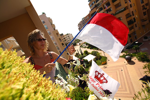 © APA/EPA/Sylvain Lefevre Eine Frau befestigt eine monegassische Flagge an ihrem Balkon
