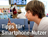 Jugendlicher mit Handy am Flughafen