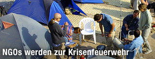 Zwei Personen unterhalten sich in einem NGO-Camp