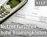 Handy liegt auf einer Rechnung