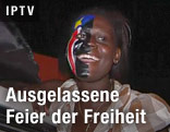 Lächelnde Frau hat Flagge auf Gesichtshälfte gemalt