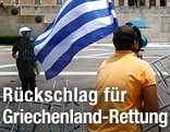 Demonstrant schwingt eine griechische Fahne