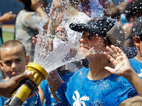 © AP/Mark Duncan Bub kühlt sich an einem Wasserschlauch ab