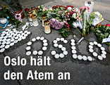 Blumen und Kerzen liegen auf einem Gehsteig in Oslo