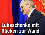 Weißrusslands Präsident Alexander Lukaschenko geht mit gesenktem Kopf an Fahnen vorbei