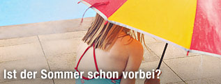 Mädchen im Bikini hält einen Regenschirm